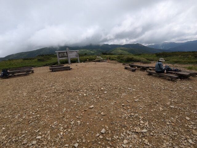 太郎平小屋前のベンチと雲がかかった薬師岳